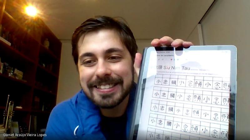 Daniel mostra na câmera a folha de treino de 小念頭 que preparou